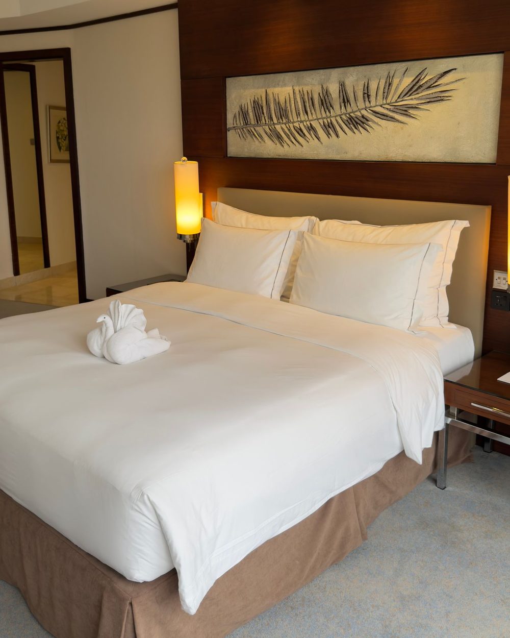 Frisch gemachtes Bett mit gefaltetem Handtuch